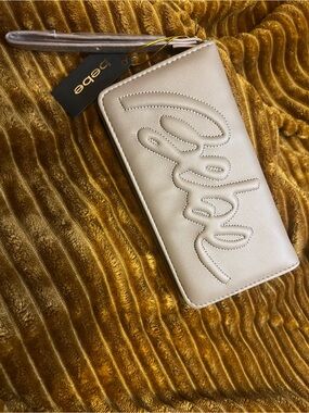 bebe Quilted Script Wristlet in Cream